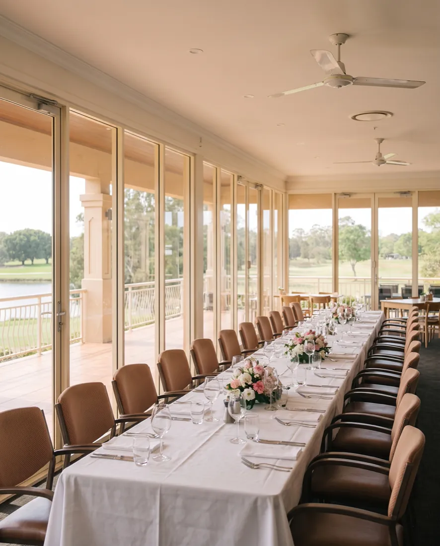 The function room set for a private event, with tables laid and the golf course through the windows
